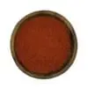 Houten kom gevuld met felrood kashmiri chilipoeder – milde Indiase chili specerij.