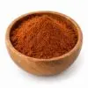 Rogan Josh currypoeder in een ronde houten kom op witte achtergrond