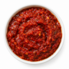 Rode harissa peperpasta in een witte ronde kom