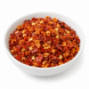 Scotch Bonnet gebroken in wit rond bakje - Kruidenkaravaan Scotch Bonnet chilivlokken in een wit rond bakje op witte achtergrond