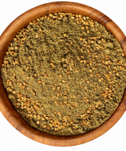 Zaatar rood in een ronde houten kom op een witte achtergrond.