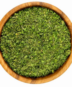 Zaatar groen in een ronde houten kom op een witte achtergrond.